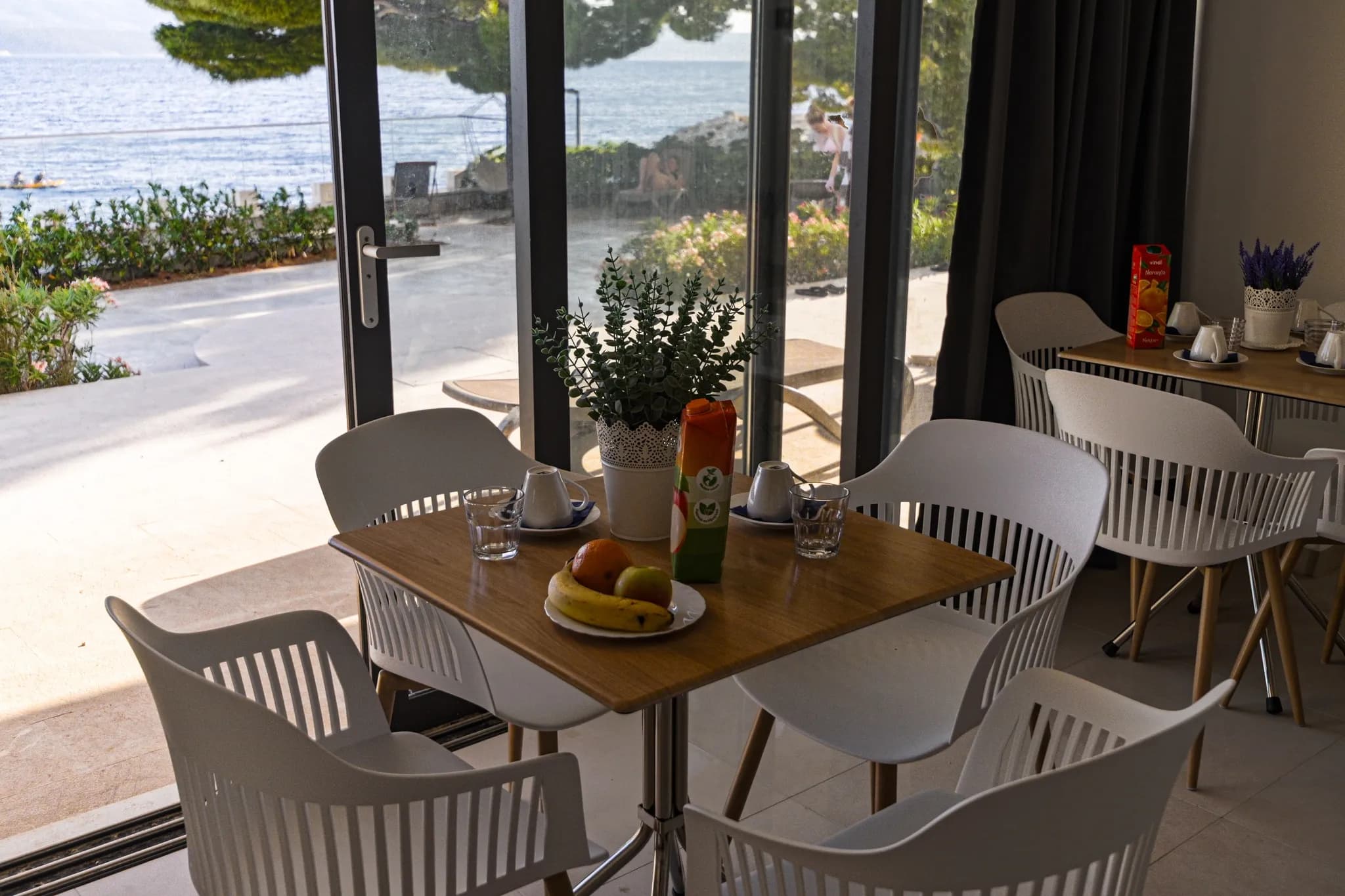 Prostor za doručak s otvorenim vratima prema plaži
