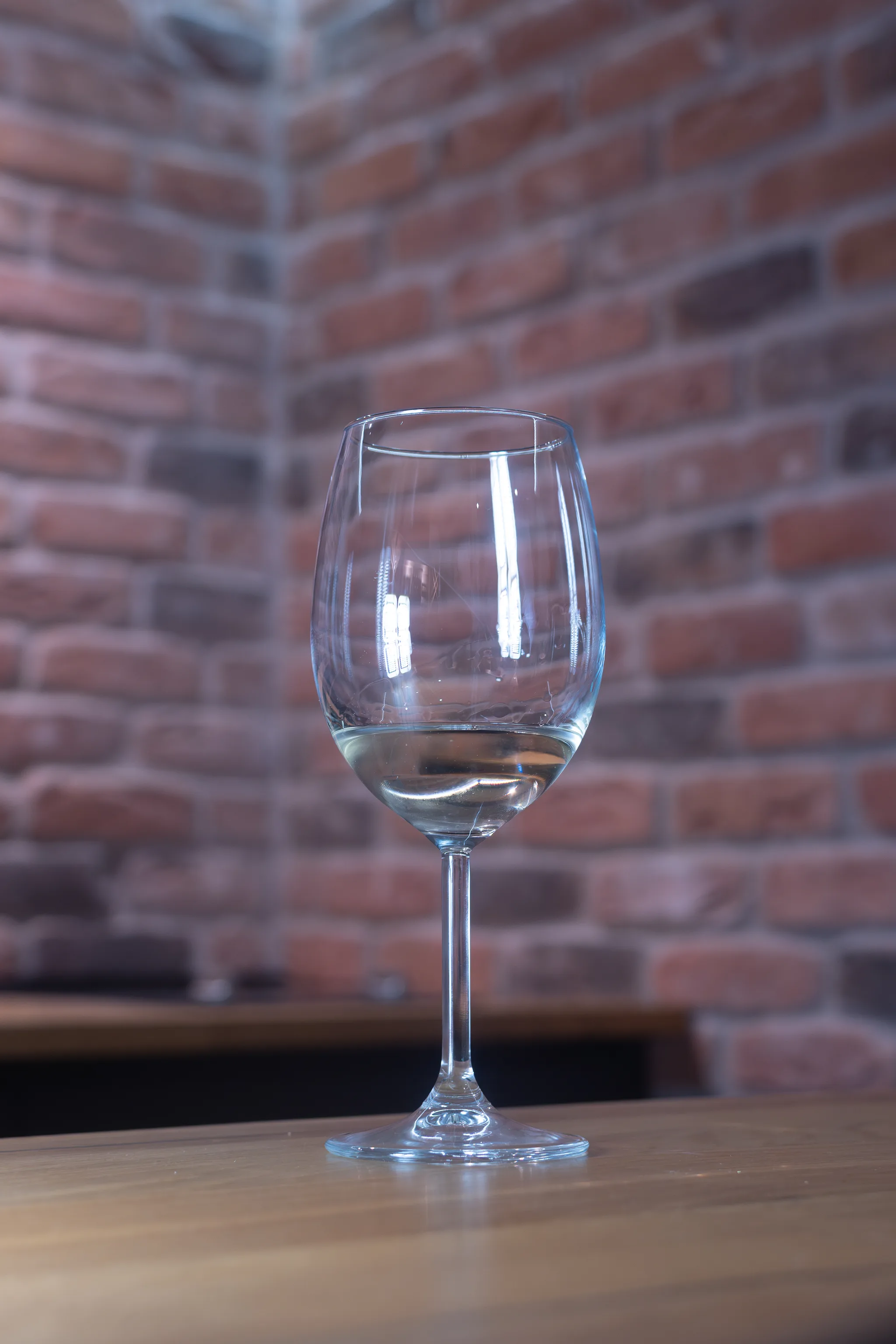 Čaša vina uz ciglani zid, degustacija