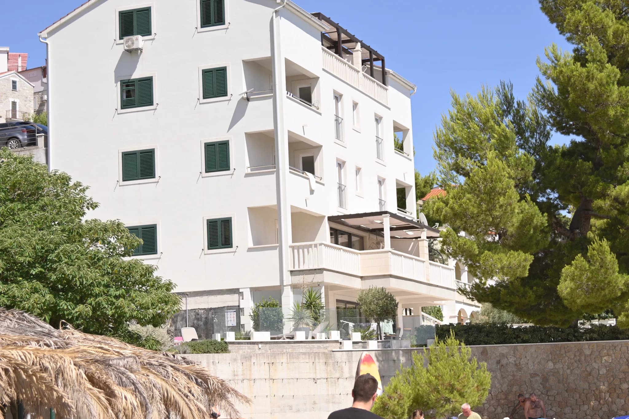 Fasada vile s pogledom na plažu i suncobranom